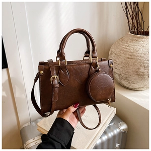 Detail of vintage brown textured leather handbag with mini coin pouch and gold hardware