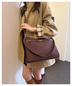 Detail of vintage matte crossbody bag with retro metal buckle and suede texture