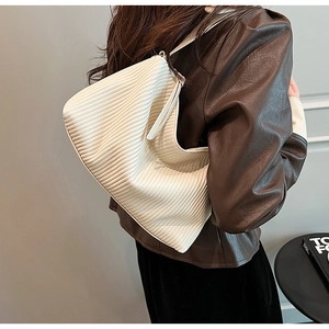 Detailed view of white pleated shoulder bag showing fine vertical textures and soft leather