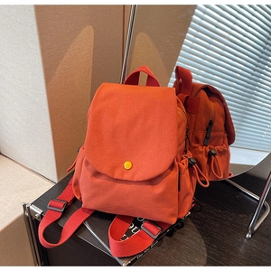 Close-up of canvas backpack featuring flap button detail and adjustable drawstring pocket