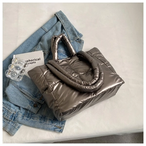 Top view of metallic coffee down quilted tote bag styled with denim jacket and books