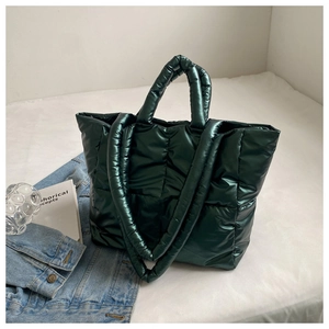 Close-up of deep green quilted tote bag with glossy finish on a white background