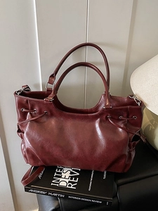 Retro burgundy tote bag in glossy leather with side drawstring detail and silver hardware