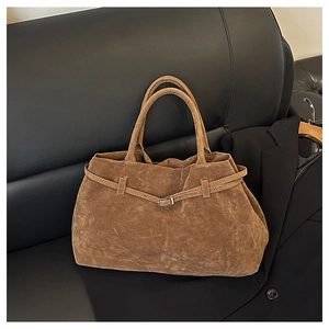 Primer plano del bolso tote de ante marrón caramelo con hebilla plateada y acabado mate