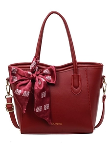 Elegante tiefrote Leder-Einkaufstasche mit festlicher Schleife und Goldschrift