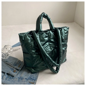 Close-up of deep green quilted tote bag with glossy metallic finish and puffer square pattern