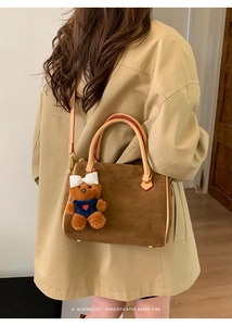 Retro brown suede pillow bag worn crossbody by a model in a minimalist indoor setting
