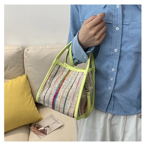 Detalle del bolso de rayas tejidas coloridas con asa amarillo neón y correa de hombro