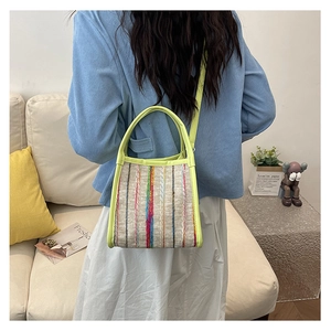 Bolso cubo de rayas tejidas de colores mostrado en un entorno de estilo de vida