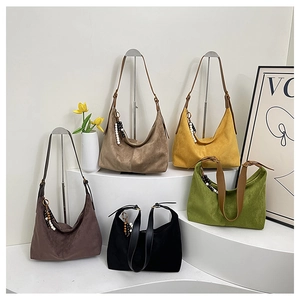 Cinq sacs hobo en daim coloré avec breloques perlées disposés sur des marches
