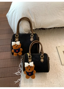 Detail of vintage matte black Boston bags with brown leather handles and bear charms