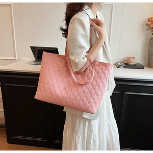Detail of pink quilted tote bag showing large capacity and elegant gold rivet handles