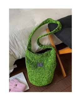 Detail der grünen Plüsch-Hobo-Tasche mit schwarzem Fashion-Label auf der Vorderseite