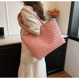 Model wearing a large pink quilted tote bag showing its generous capacity and elegant style