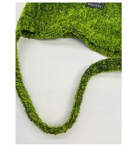 Detail van de groene fleece draagtas met brede schouderband en het merklabel