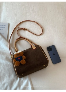 Detail of vintage matte cylinder Boston bag in dark brown with plush bear charm