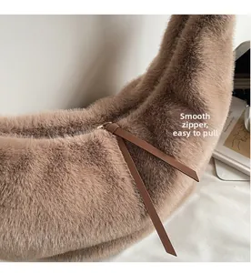 Detail view of the smooth metal zipper and plush faux fur texture on a brown shoulder bag