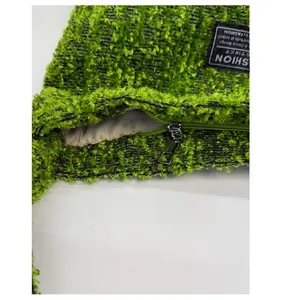 Detail der hellgrünen Plüschtasche mit silbernem Reißverschluss und Texturgewebe