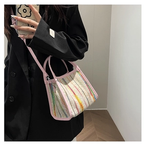 Bolso bandolera tejido de moda con ribete de cuero rosa mostrado en modelo con blazer