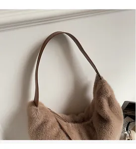 Detail of soft brown plush material and adjustable leather shoulder strap of the bag