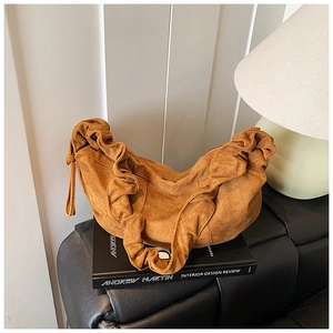 Detailed view of caramel suede dumpling bag with pleated ruffles and soft slouchy texture