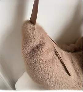 Detail of soft light brown faux fur texture and smooth dark leather strap of a shoulder bag