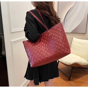 Detailed macro view of the classic red quilted texture on this large capacity tote bag