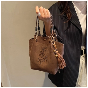 Détail du sac seau marron café avec poignée en corde tressée et broderie nœud noir