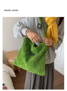Model draagt een groene wollen tote bag met modelabel in een gezellige slaapkameromgeving