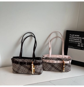 Detail of vintage plaid shoulder bags with leather straps and decorative bead tassels