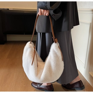 Detail of white faux fur hobo bag with brown leather strap and soft fluffy texture