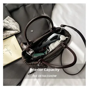 Vue intérieure d'un sac seau plissé marron foncé montrant la capacité pour téléphone