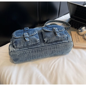 Detail of vintage denim shoulder bag showing double front pockets and metal buckles
