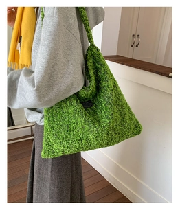 Gedetailleerde textuur van groene wollen draagtas met zwart vierkant patch-decoratie