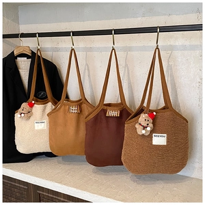 Detailansicht stilvoller Plüsch-Tragetaschen mit SEEYOU-Label und Bärenanhänger