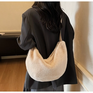 Detailed close-up of a beige faux fur crescent hobo bag worn by a model in soft light