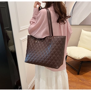 Detail of coffee tote bag featuring diamond quilted texture and elegant metal rivets