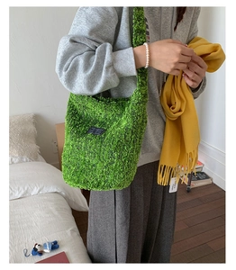 Detail der grünen Plüschtasche mit FASHION-Aufnäher, getragen in gemütlichem Innenraum