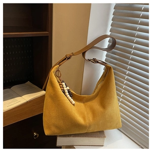 Détail du sac hobo en daim avec charm en perles de bois et bandoulière réglable
