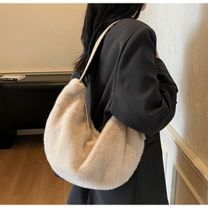 Detail of soft beige faux fur hobo bag with slim leather strap for winter styling