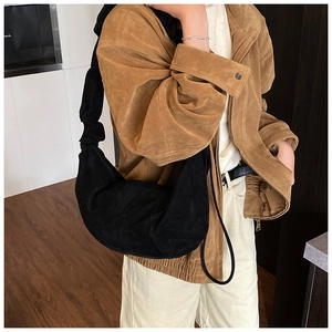 Detail showing the black suede hobo bag with a stylish ruched gathered shoulder strap