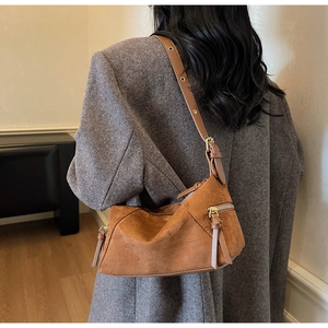 Detail of caramel suede hobo bag with long fringe tassel zipper and adjustable strap