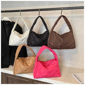Quilted oversized hobo shoulder bags in multiple colors displayed on a studio shelf