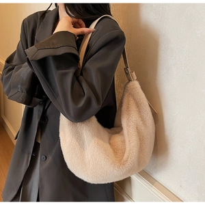 Detail of soft cream faux fur shoulder bag with adjustable leather strap on model