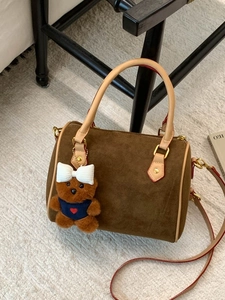 Vintage brown frosted suede Boston handbag with cute teddy bear charm on carpet