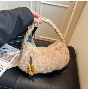 Detail of light beige plush tote bag featuring a braided handle and colorful bead charm