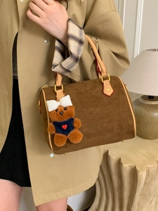 Brown suede Boston handbag with bear charm and scarf, styled with a beige trench coat