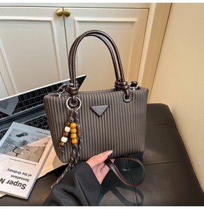 Détail du sac seau plissé marron foncé avec breloque en perles de bois et bandoulière