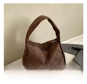 Detail show of coffee brown quilted pillow bag with silver zipper and shiny nylon texture