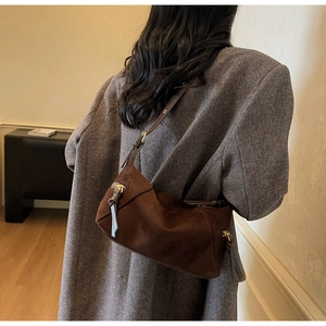Detailed close-up of dark brown suede hobo bag with gold hardware and leather trim